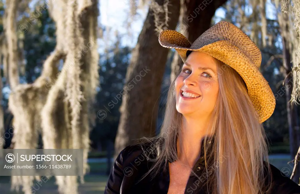 beautiful blonde middle aged woman cowgirl with cowboy hat on.