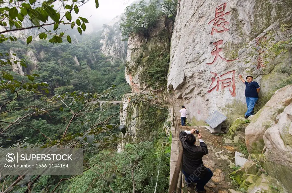 Tourists pose for pictures on the trail to the San Huang Zhai Monastery on Song Mountain