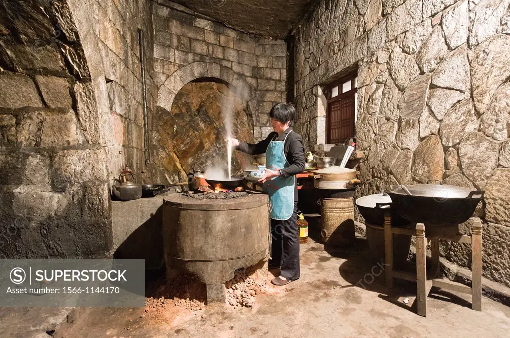 A woman cooks in a traditional Shaolin kitchen at the San Huang Zhai Monastery on the Song Mountain, China