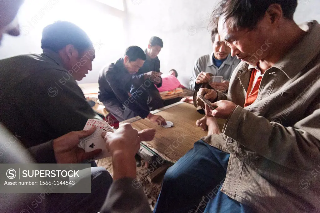 Labor workers playing a friendly game of cards at the San Huang Zhai Monastery on Song Mountain, China