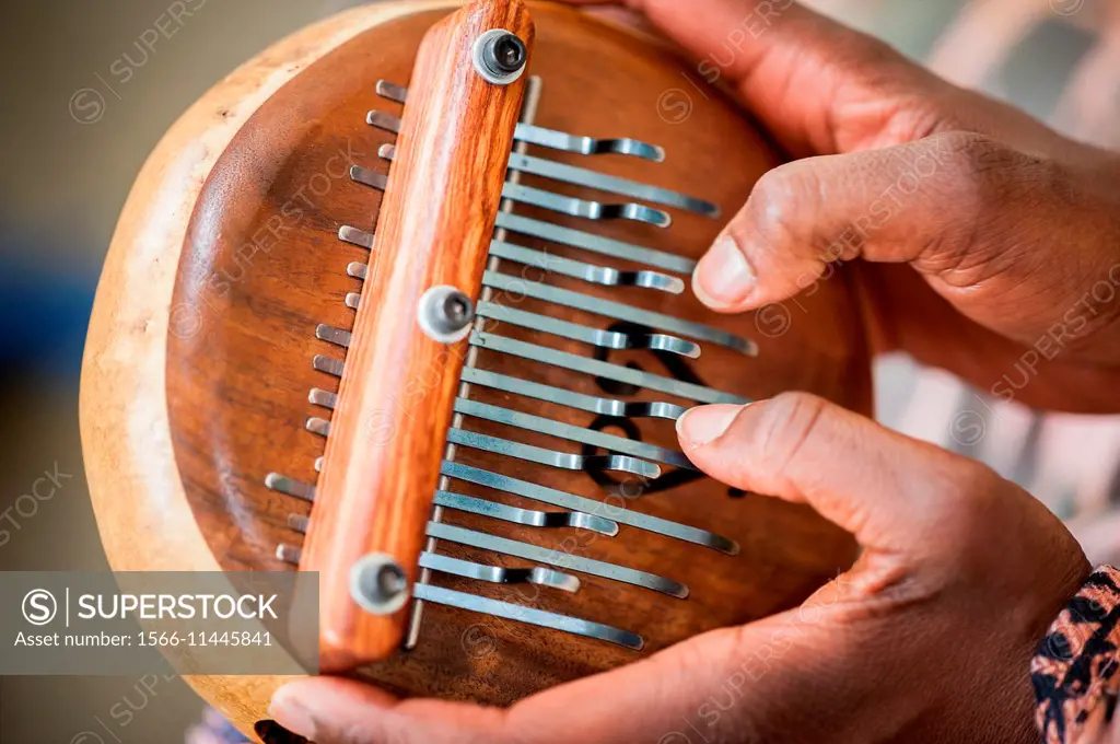 Close-up of African American hands playing a lamellophone musical instrument.