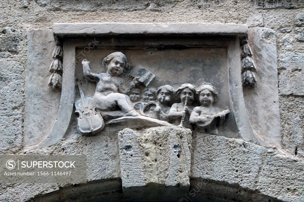 A quartet of cherubs over a doorway indicates the home of a musician