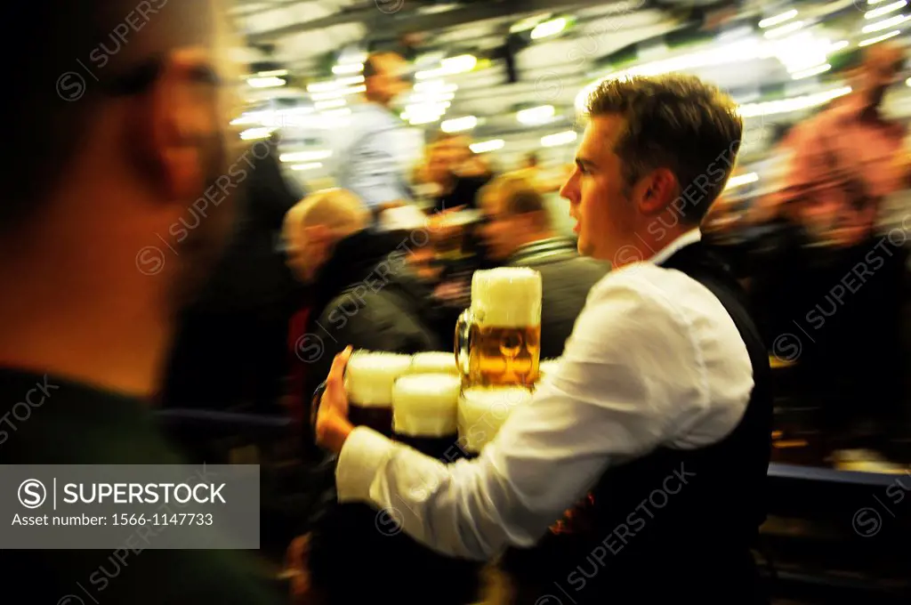 Male waiter with beer steins during Oktoberfest festival in Munich,Germany