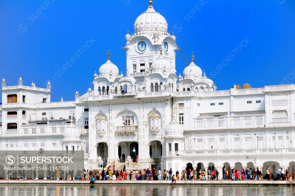 India. Punjab. Amritsar. The Golden Temple. The Parikrama Marble Path or ambulatory for Sikh believers, and the Ghanta Ghar Deohdi Gate of Victorian s...