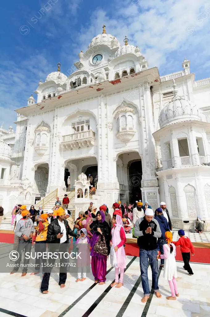 India. Punjab. Amritsar. The Golden Temple. The Parikrama Marble Path where Sikh believers pray, and the Ghanta Ghar Deohdi Gate of Victorian style.