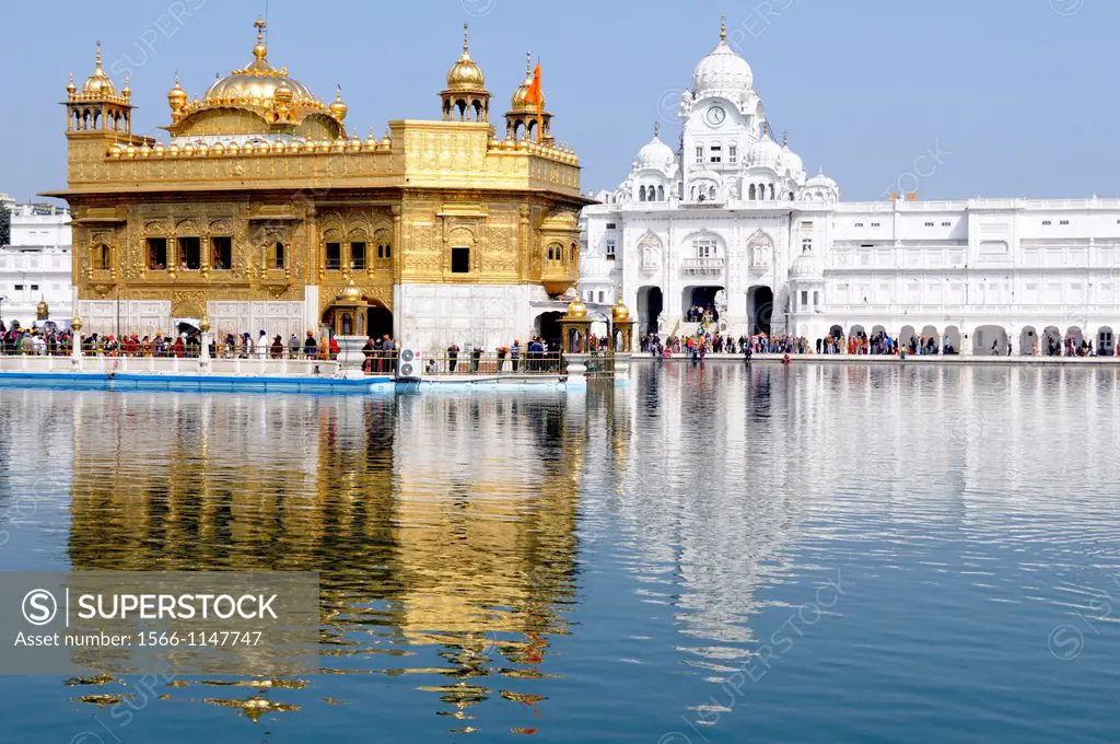 India. Punjab. Amritsar. The Golden Temple. The Sri Harmandir Sahib the holy of holies of Sikhism, hindu-islamic style. To the right the Victorian tow...