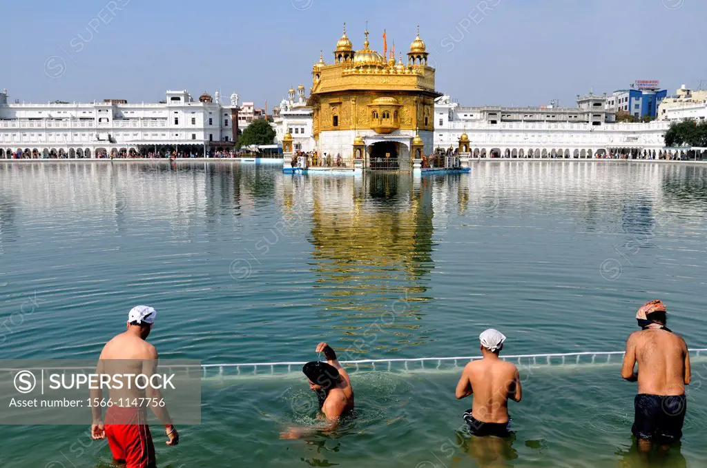 India. Punjab. Amritsar. The Golden Temple. Believers Sikh in front of the sacred pool Anrit Sarovar and the Sri Harmandir Sahib the holy of holies of...