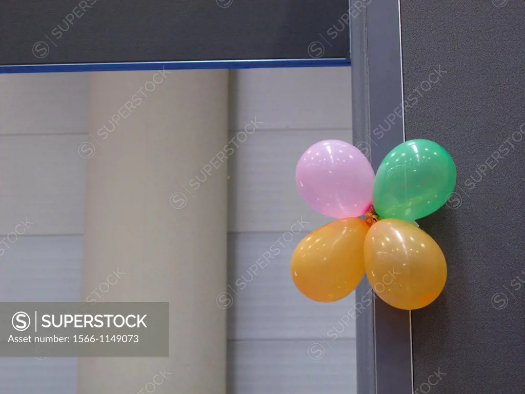 four colourful balloons on office dividing wall at conference hall