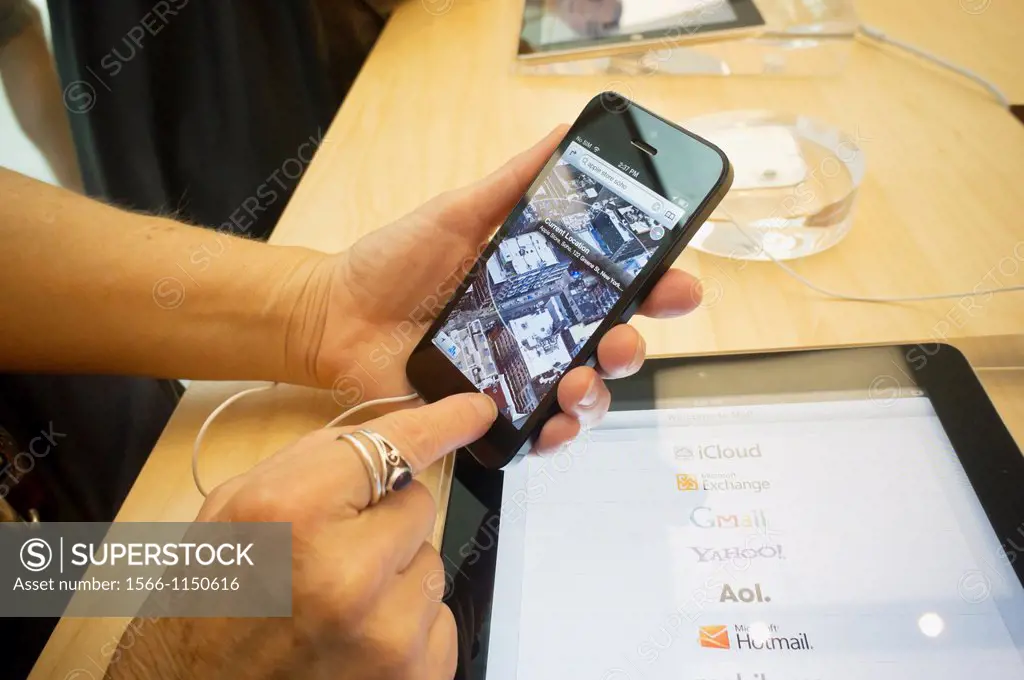 A consumer tries a new iPhone 5 in an Apple store in Soho in New York News media reports problems with the new operating system, iOS 6, specifically w...