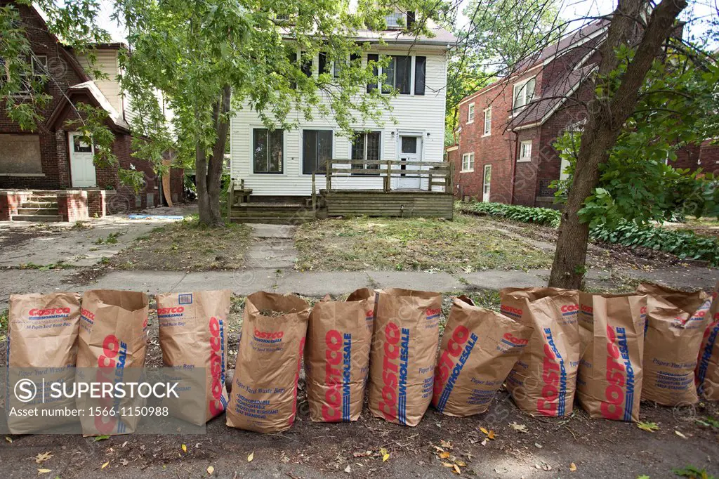 Detroit, Michigan - A row of yard waste bags is ready for collection after the Three Mile Drive Block Club cleaned up the lawn of a vacant home on the...