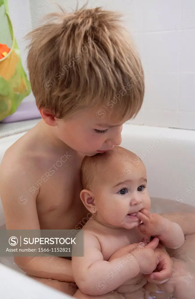 5 year old boy and his 6 months old sister in bathtub