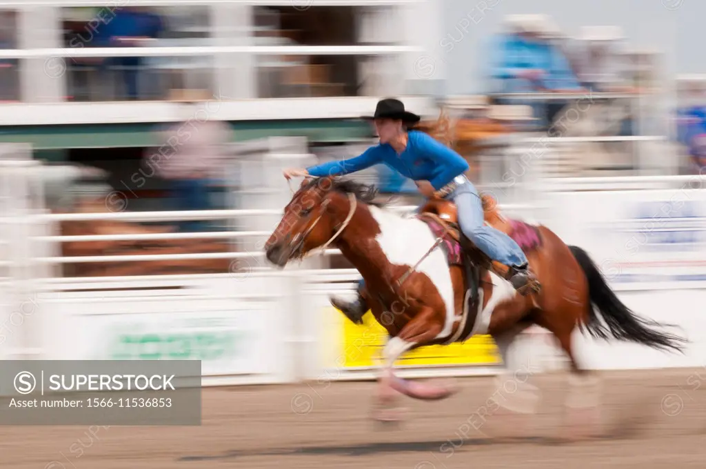 Motion blur of a cowgirl riding fast during barrel racing, Sundre Pro Rodeo, Sundre Alberta, Canada.