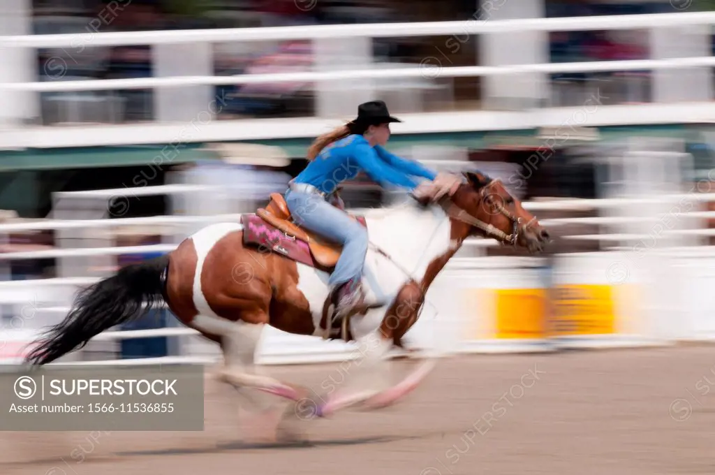 Motion blur of a cowgirl riding fast during barrel racing, Sundre Pro Rodeo, Sundre Alberta, Canada.