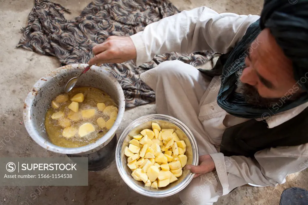 Afghan refugees preparing a potatoe meal, Afghanistan