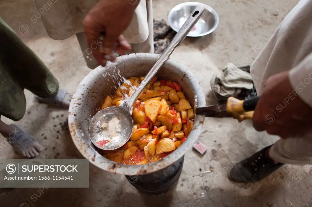 Afghan refugees preparing a potatoe meal, Afghanistan