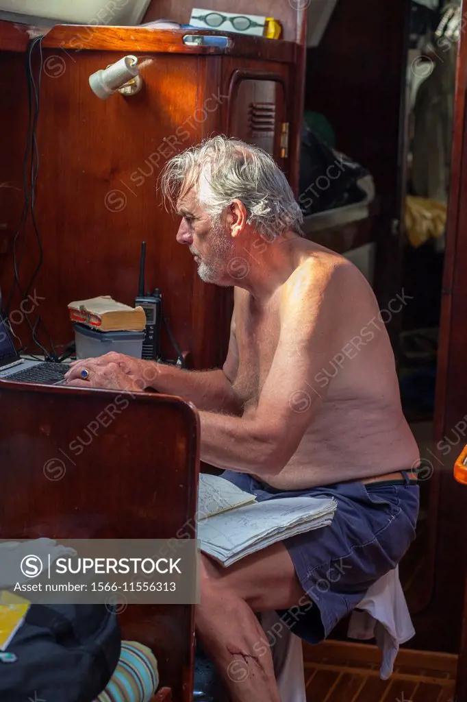 Captain checking charts on sailboat, Belize