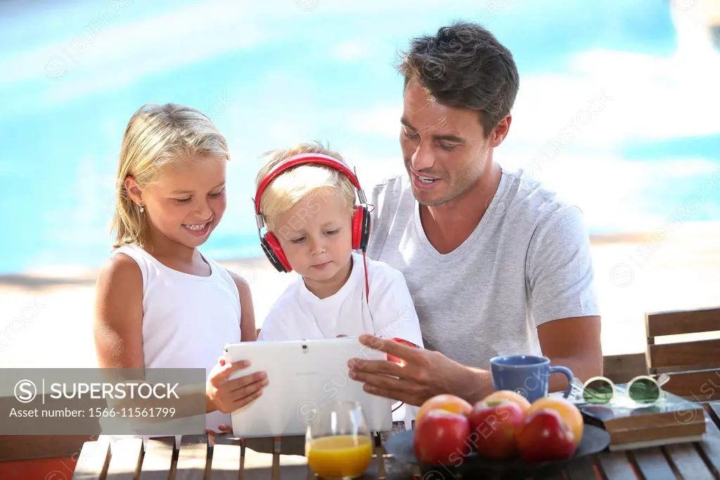Father and children with digital tablet and headphones