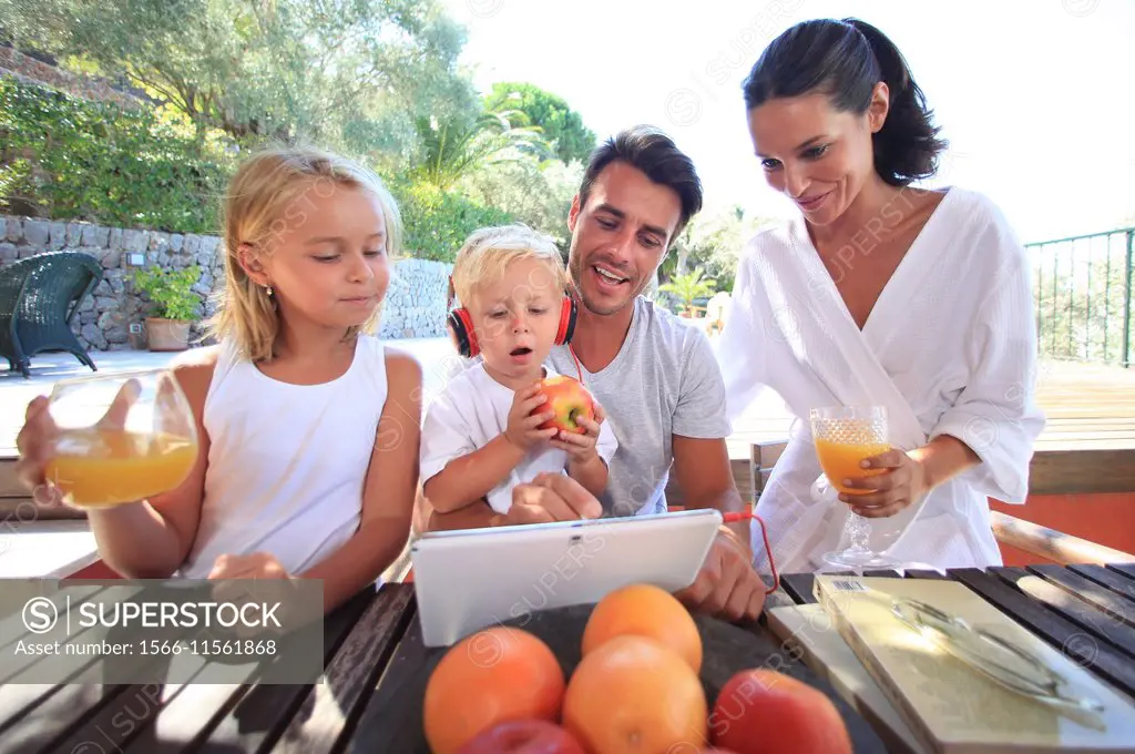Family, looking at digital tablet