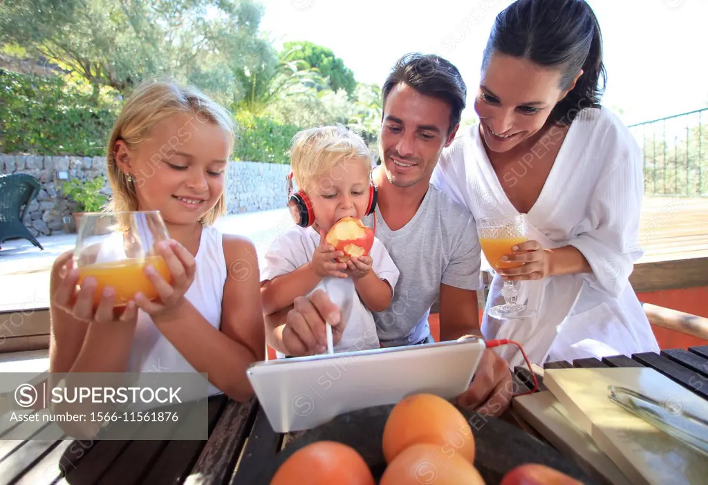 Family, looking at digital tablet