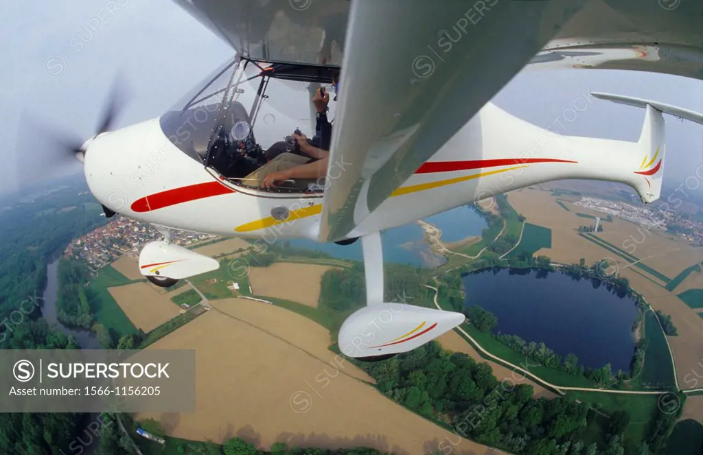 Ultralight plane Allegro flying over lake near Haguenau, Alsace region, France