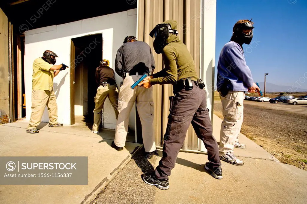 Working as a team, male and female female law enforcement agents practice entering or ´breaching´ a room with weapons at a Southern California ´simuni...
