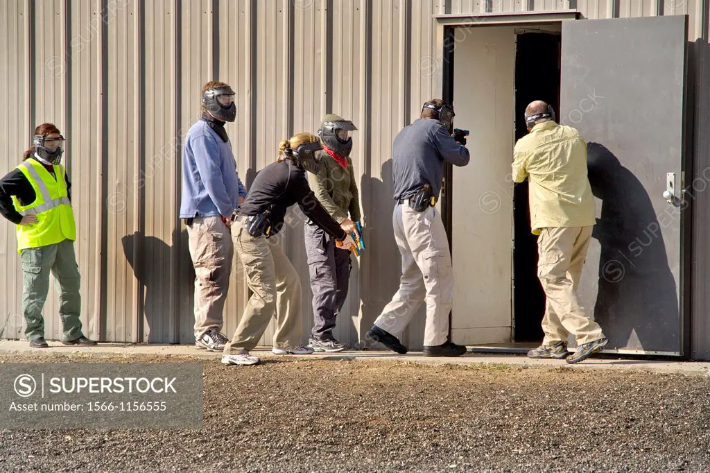 Working as a team, male and female female law enforcement agents practice entering or ´breaching´ a room with weapons at a Southern California ´simuni...