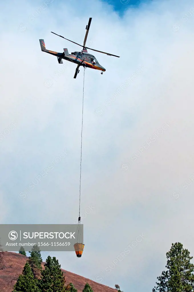 Helicopter, Firefighting on the Springs Fire with the Kaman Firemax helicopter with a dip bucket at the Payette River in the North Fork Mountains near...