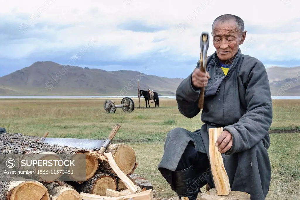 Man chopping wood to make fire, Tsagaan Nuur. Mongolia.