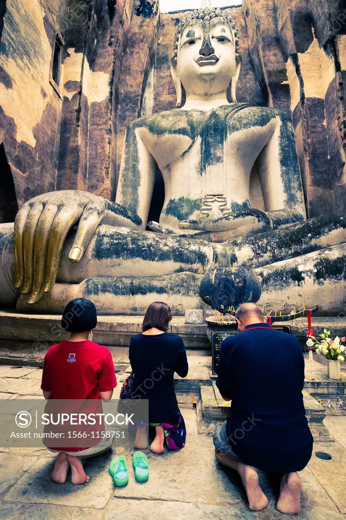 Believers in a Buddha statue  Wat Sri Chum  Sukhothai Historical Park  Thailand