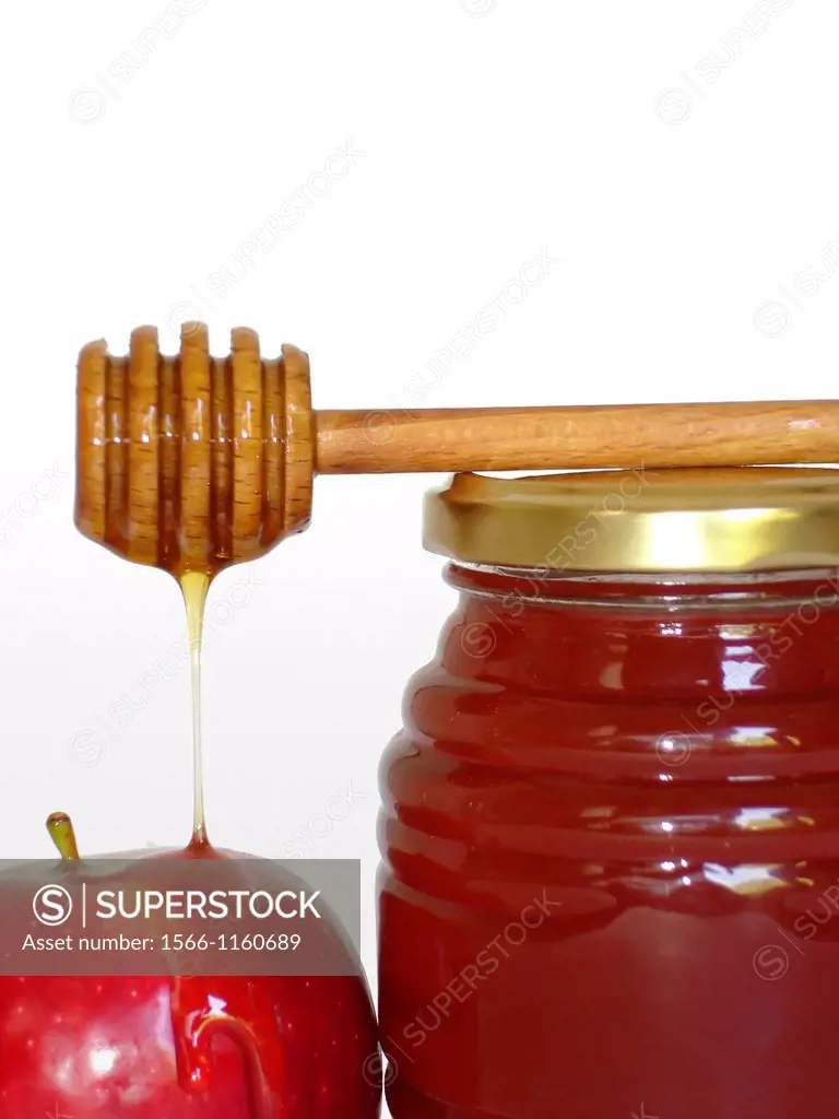 Jar of honey, honey dipper stick and a red apple - symbols of the Jewish holiday of Rosh Hashanah isolated on white background