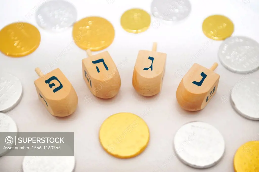 Photo of dreidels spinning tops and gelts candy coins for Hanukkah isolated on white