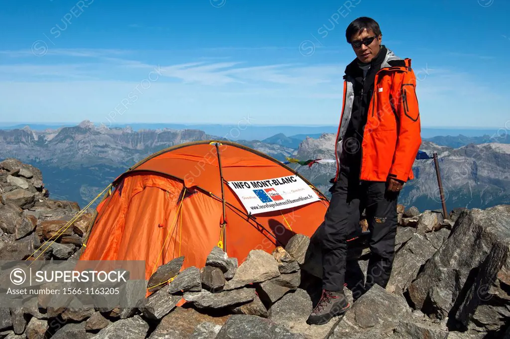 Young man from Nepal as mountain ranger at an information desk at about 3100 meters above sea level for climbers of the Mont Blanc peak on the classic...