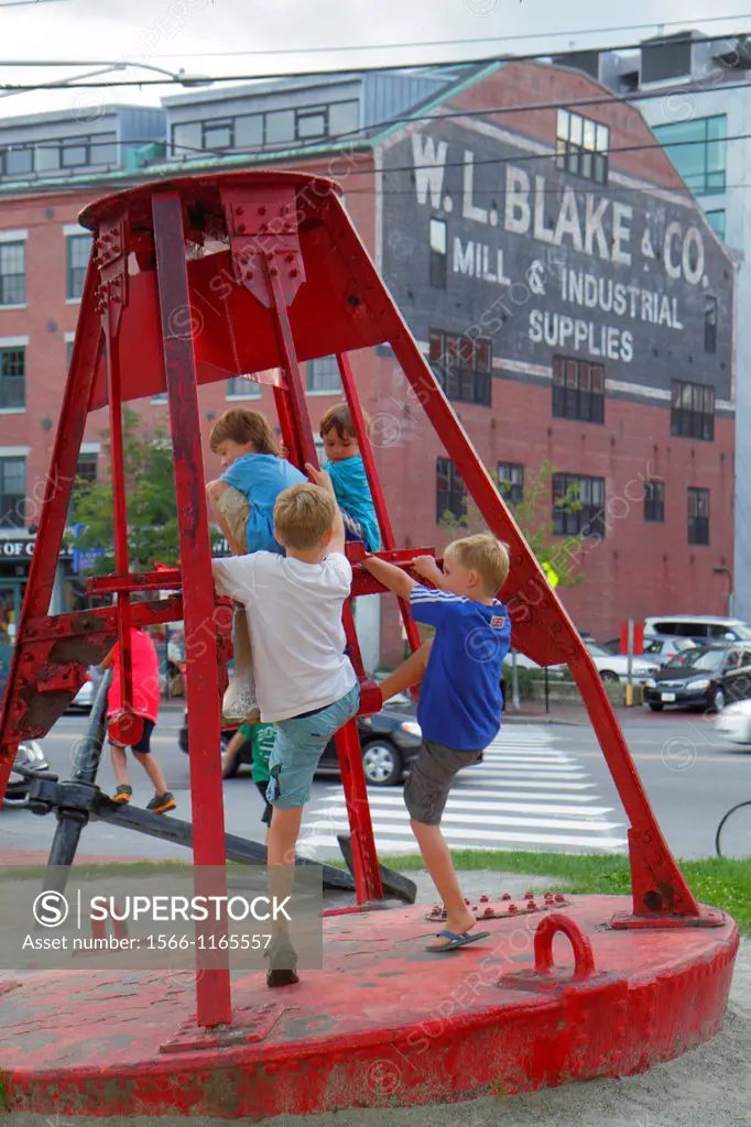 Maine, Portland, Historic Old Port District, Commercial Street, red ocean bouy, boy, climbing,