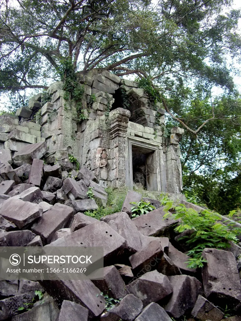 Beng Mealea temple with collapsed stone blocks and tree roots overtaking the building in Cambodia