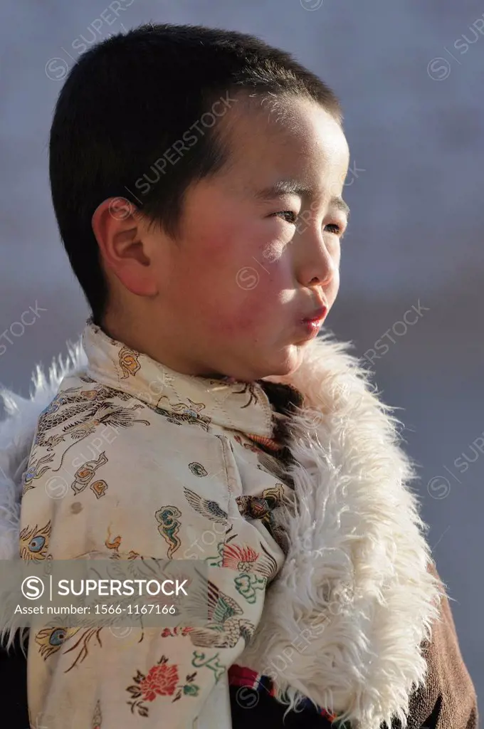 China, Qinghai, Amdo, Tongren Rebkong, Sangyeshang village, Lower Wutun monastery, Losar, New Year festival, Young tibetan boy in full attire