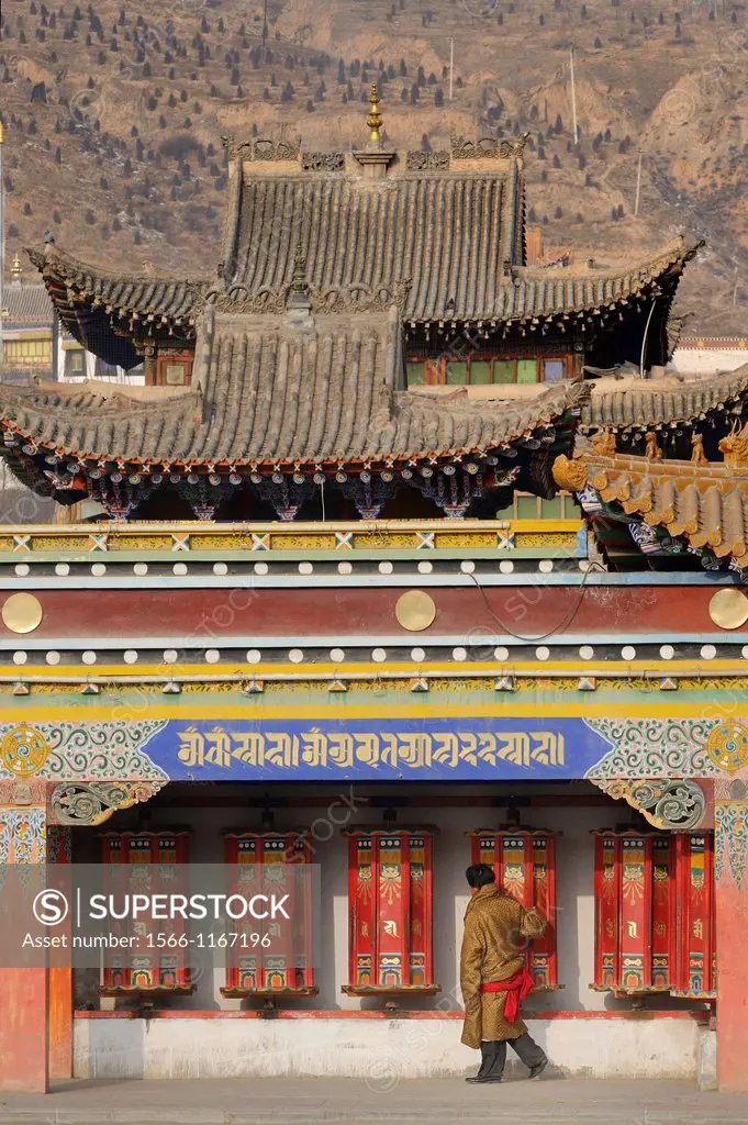China, Qinghai, Amdo, Tongren Rebkong, Monastery of Rongwo Longwu Si, Devotee spinning prayer wheels