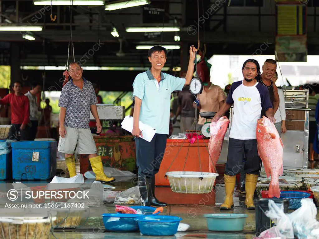 FIshermen and workers at an open air fish market in Johor, Malaysia