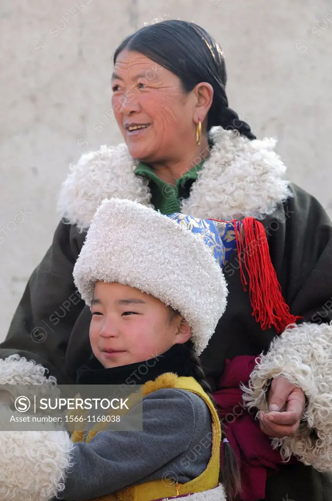 China, Qinghai, Amdo, Tongren Rebkong, Monastery of Gomar Guomari Si, Losar New Year festival, Mother an child in full attire