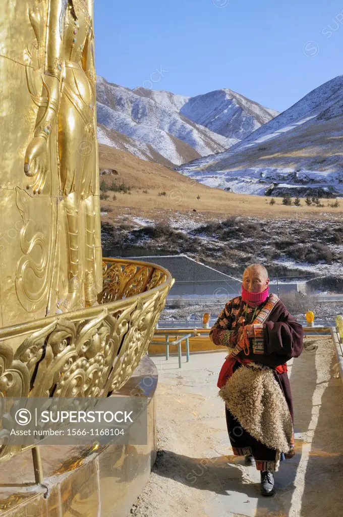 China, Gansu, Amdo, Xiahe, Monastery of Labrang Labuleng Si, Tibetan devotee in prayer on top of Gongtang chorten