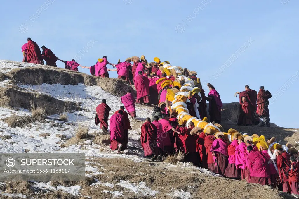 China, Gansu, Amdo, Xiahe, Monastery of Labrang Labuleng Si, Losar New Year festival, Giant Thangka bearers climbing uphill