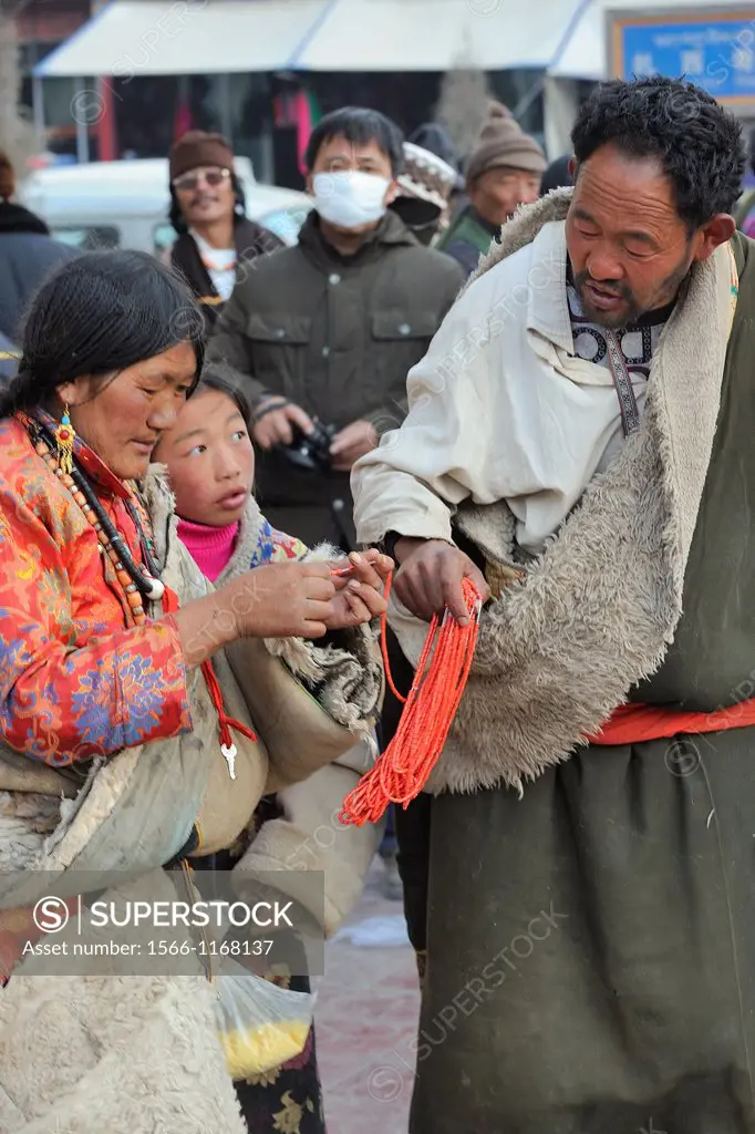 China, Gansu, Amdo, Xiahe, Losar New Year festival, Open air market, Tibetan couple buying a coral necklace