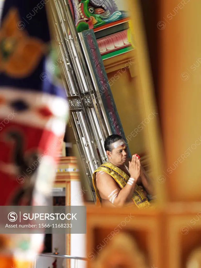 The Chief Priest praying and performing holy rituals inside a Hindu Temple in Malaysia