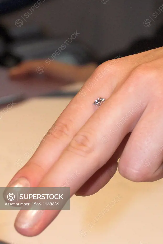 Guide displays cut diamond on fingers Gassan Diamonds building Amsterdam The Netherlands