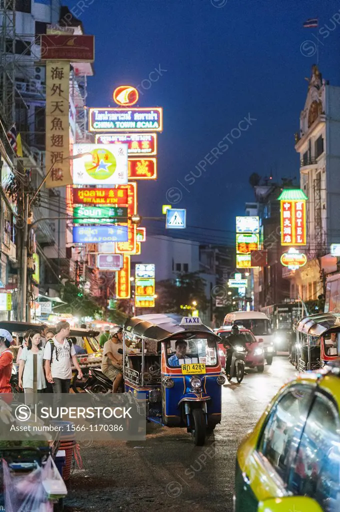 A Tuk Tuk driving through the streets of Bangkok at night