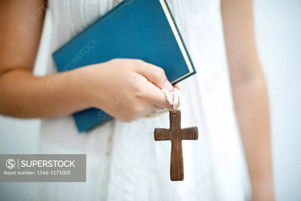 Young religious youth with cross in hand and religios book