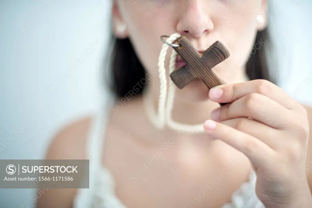 portrait of young nun kissing a cross,