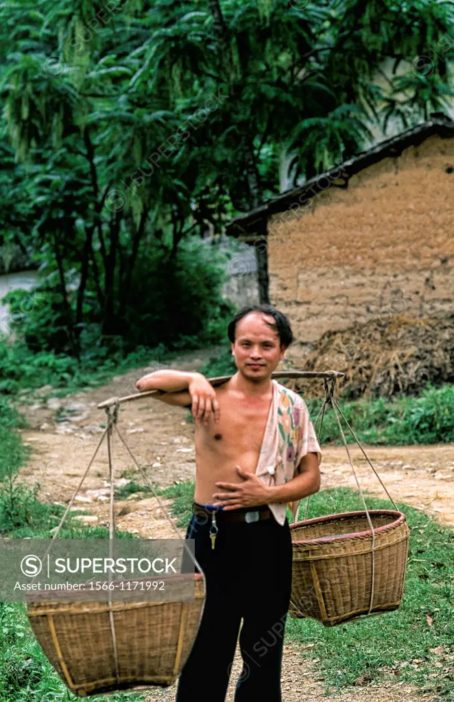 Farmer with baskets near the Li River in Guilin China