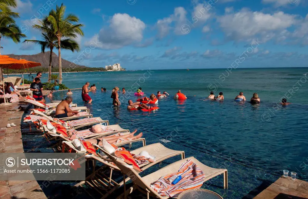Tourists relaxing at edgeless pool at Sheraton Waikik Beach Hotel in Honolulu Hawaii Oahu