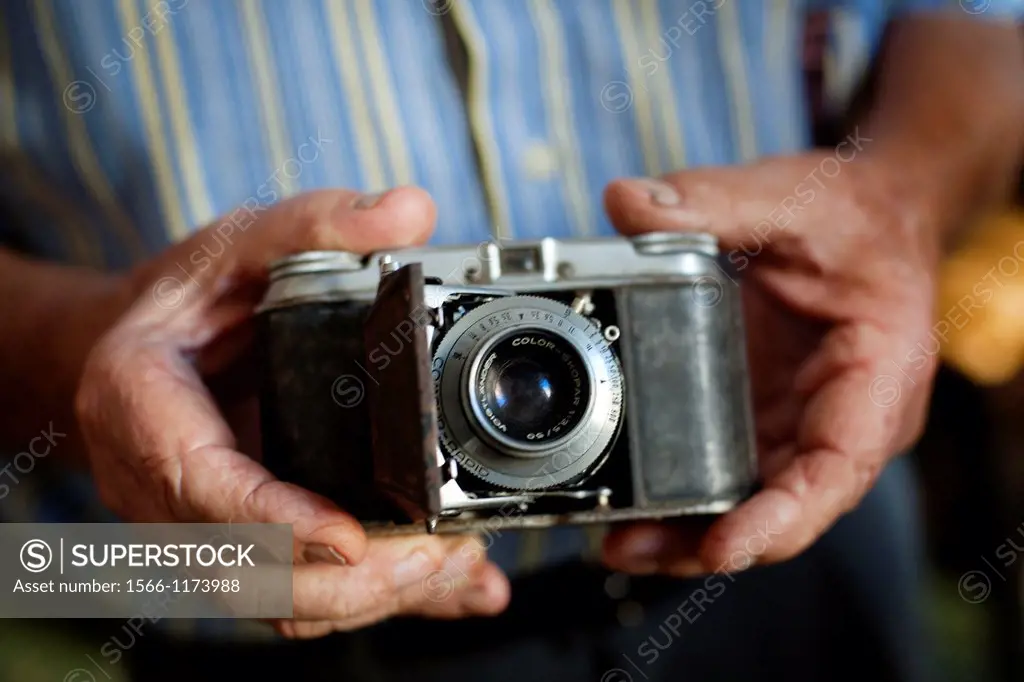 Manos mostrando camara antigua Voigtlander, Hands showing old Voigtlander camera,