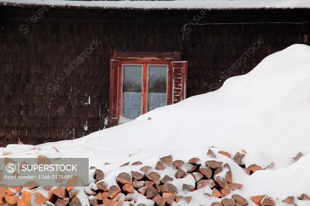 stack of firewood in front of old historic building in winter at the village Prasily, German: Stubenbach, near Susice, Okres Klatovy, Bohemia, Czech R...